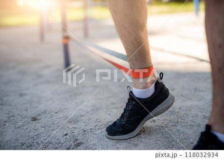 Male legs training with elastic rubber Male legs training with elastic rubber 118032934