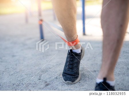 Male legs training with elastic rubber Male legs training with elastic rubber 118032935