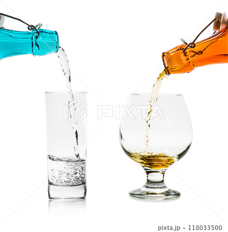 Filling the glasses with liquid from blue and orange glass bottles isolated 118033500
