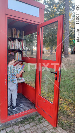 Toddler boy sitting in a crossbooking booth and reading a book. Self-education concept for children, Education concept, prep or elementary school. Toddler boy sitting in a crossbooking booth and reading a book. Self-education concept for children, Education concept, prep or elementary school. 118034456