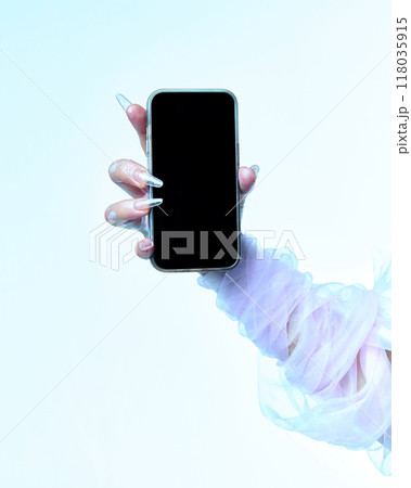 Hand of spooky white ghost holding smartphone with blank screen against gradient background. Negative space for your ad. Hand of spooky white ghost holding smartphone with blank screen against gradient background. Negative space for your ad. 118035915