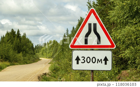 road signs warning of narrowing of the road, on a dirt road 118036103