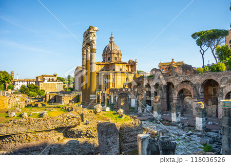 Santi Luca e Martina stands majestically in Rome, nestled between the Roman Forum and the Forum of Caesar. Sunlight illuminates the historic architecture amidst the ancient ruins. 118036526