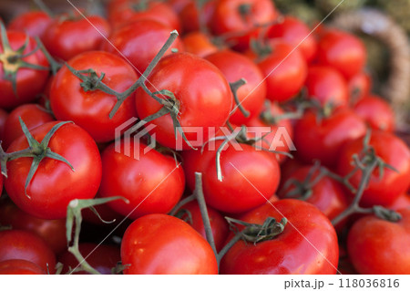 Red fresh tomatoes on branch in wicker baskets on counter 118036816