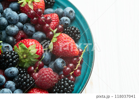 Mix of ripe colorful berries in bowl photography . Blueberry , strawberry , raspberry . Top view 118037041