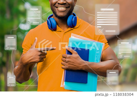 A man in an orange shirt points to a book in his hand A man in an orange shirt points to a book in his hand 118038304