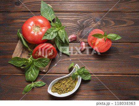 Basil pesto, fresh basil leaves, tomatoes and garlic on wooden background. ingredients for cooking. 118038363