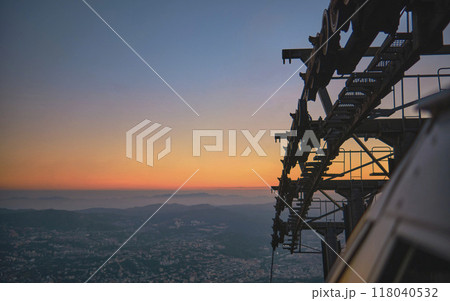Closeup, Modular cabins cable car against the bright sky, clouds and mountains. Cableway - one of the popular urban rides in Caracas. toned image. Closeup, Modular cabins cable car against the bright sky, clouds and mountains. Cableway - one of the popular urban rides in Caracas. toned image. 118040532