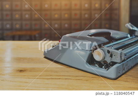 Retro old typewriter on blur background and front of wooden table. Vintage concept, selective Focus. Retro old typewriter on blur background and front of wooden table. Vintage concept, selective Focus. 118040547