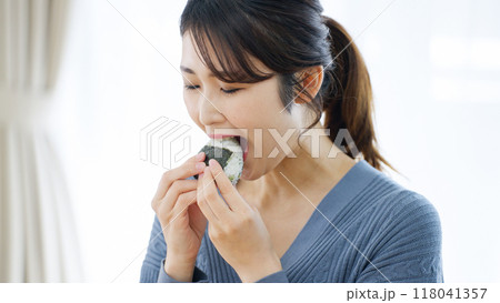 おにぎりを笑顔で食べる女性 118041357