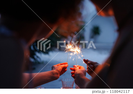 girls celebrate with sparklers in their hands in the evening, holiday concept 118042117