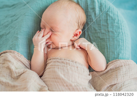 The baby is sleeping peacefully in his cozy nest. Newborn photo session captures the serene innocence and warmth of early moments 118042320