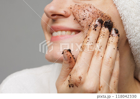 Woman enjoying facial skin care, applying black coffee face scrub, concept of rejuvenation and facial skin care Woman enjoying facial skin care, applying black coffee face scrub, concept of rejuvenation and facial skin care 118042330