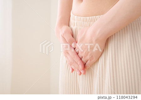 お腹に手を当てる女性 118043294