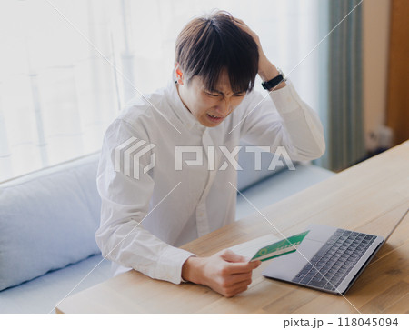 通帳を見る男性 118045094