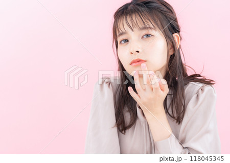 ピンクバックでスキンケアをする若い女性 118045345