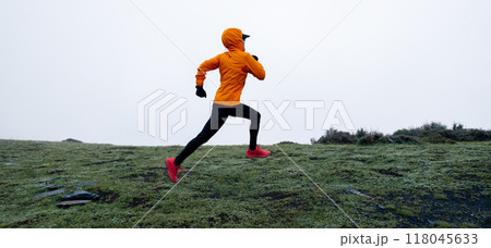 Woman trail runner cross country running to high altitude mountain peak Woman trail runner cross country running to high altitude mountain peak 118045633