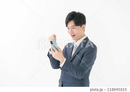 スマホを見ながらガッツポーズをするビジネスマン 118045833