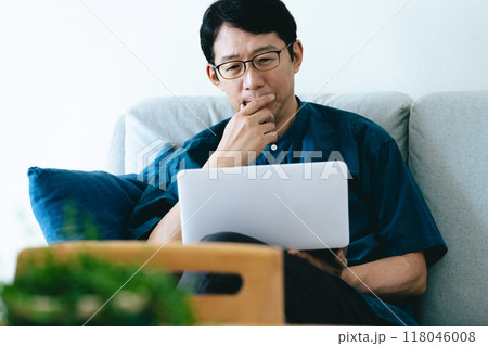 ソファでパソコンを操作する男性 118046008
