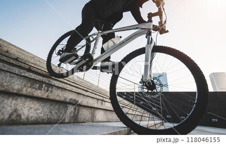 Woman free rider riding bike going down city stairs Woman free rider riding bike going down city stairs 118046155