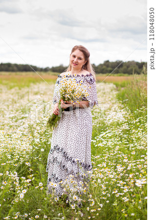 Beautiful woman in the field with flowers. Beautiful woman in the field with flowers. 118048050