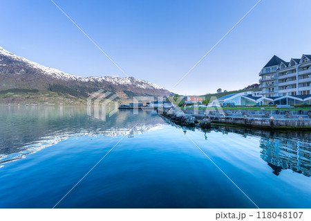 Tranquil Fjord Village Nestled Among Mountains. 118048107