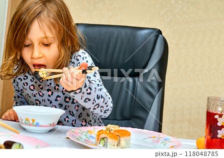 Wonderful hungry child is happy to eat sushi with soy sauce 118048785