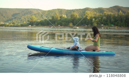 Embark on a Serene Paddleboarding Adventure on a Beautifully Calm Lake, Embracing Nature Embark on a Serene Paddleboarding Adventure on a Beautifully Calm Lake, Embracing Nature 118048808