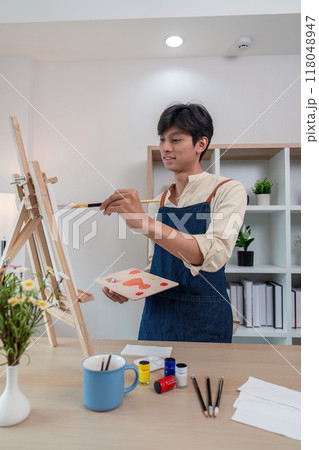 Young artist painting in a personalized studio space 118048947