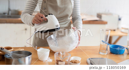 Woman using hand mixer to prepare dessert batter Woman using hand mixer to prepare dessert batter 118050169
