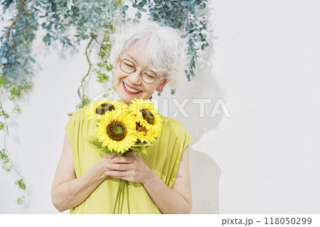 ひまわりを持つシニア女性 118050299