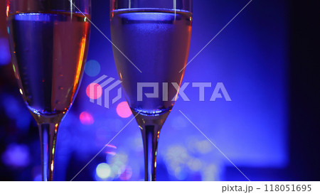クリスマスディナーのシャンパングラス、立ち上る気泡にイルミネーションの光がきらきらと反射する夜の背景 118051695
