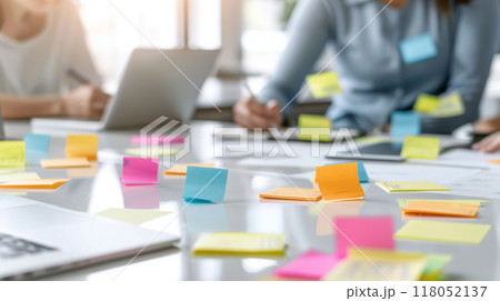 A table with a laptop and a woman writing on a piece of paper A table with a laptop and a woman writing on a piece of paper 118052137