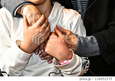 Affection and tenderness of a granddaughter to her grandmother. Traits of aging on the hands Affection and tenderness of a granddaughter to her grandmother. Traits of aging on the hands 118052573