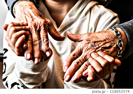 Affection and tenderness of a granddaughter to her grandmother. Traits of aging on the hands	 118052574