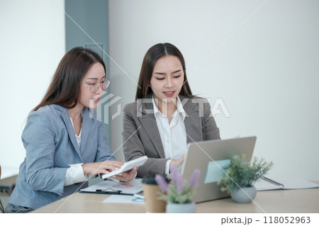 They are looking at the screen and discussing something 118052963