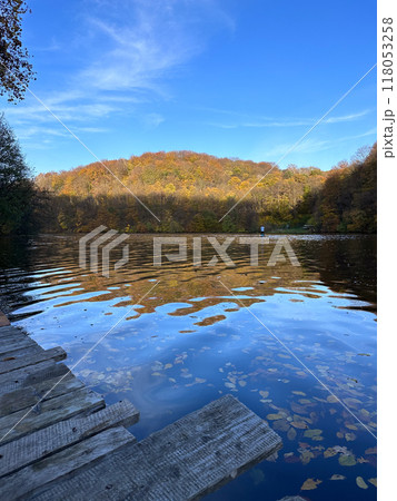Man Paddleboarding in Autumn Lake Man Paddleboarding in Autumn Lake 118053258