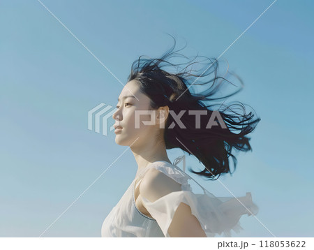 青空と風に舞う、穏やかな表情のアジア人女性 118053622