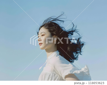 青空と風に舞う、穏やかな表情のアジア人女性 118053623