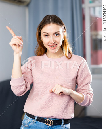 Portrait of an emotional girl pointing her finger at something in apartment 118054100