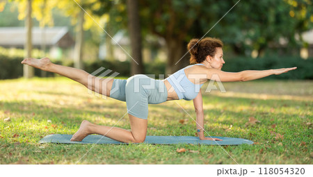 Adult woman doing yoga in park Adult woman doing yoga in park 118054320