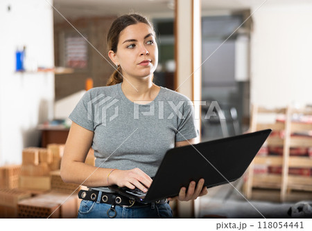 Woman with laptop on indoor construction site 118054441
