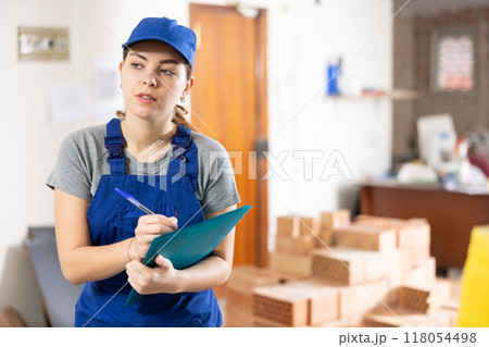 Woman architect taking notes on construction site Woman architect taking notes on construction site 118054498