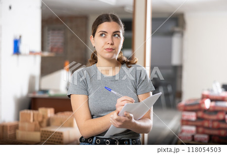 Girl making notes while planning house renovation and remodeling 118054503
