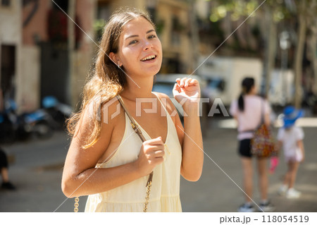 Portrait of a young girl in a light summer dress on city street during the day 118054519