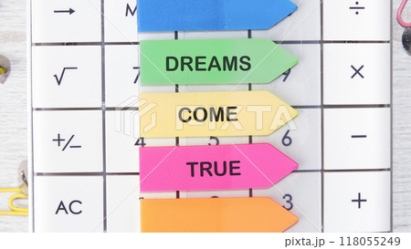 Conceptual dreams come true symbol. Copy space. Dreams come true words on the arrow-shaped stickers on the calculator 118055249