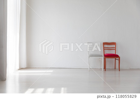 Two old vintage chairs in the interior of a white room near the wall 118055829
