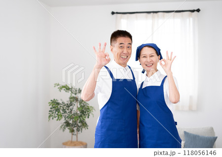 青色のエプロンを付けた白いポロシャツのシニアのハウスキーパー（男女、夫婦、独立、引退後） 118056146