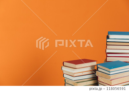 Piles of books for study in the library on an orange background 118056591