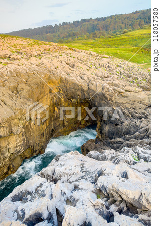 Famous natural sea cave at Llanes Asturias, Spain. landscape of the waves splashing at a natural Famous natural sea cave at Llanes Asturias, Spain. landscape of the waves splashing at a natural 118057580